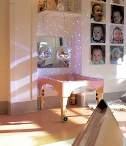 A disco ball casts sunlight across the wall at UVM's Campus Children's School