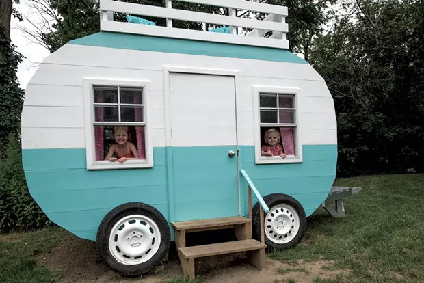 Nora and Claire peek through the working windows of their new playhouse - COURTESY OF RICH LEVINE