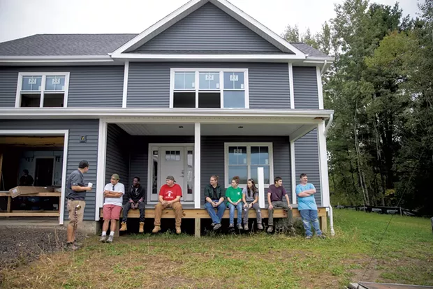 Essex tech instructor Chris Welch (left) reviews the morning's progress with students at the home they are building in Essex Junction - JAMES BUCK