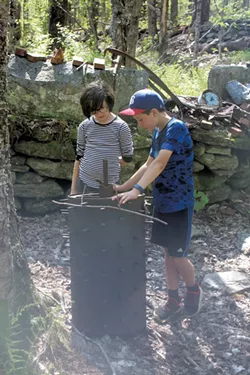Scarlett and Jesse examining old farm machinery - HEATHER FITZGERALD