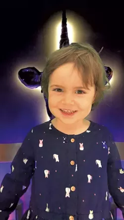 Coraline doing standup comedy in front of a Vermont Comedy Club green screen - COURTESY OF KEEGAN ALBAUGH