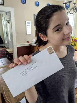 Evelyn Fleming holding up her letter to Gov. Phil Scott