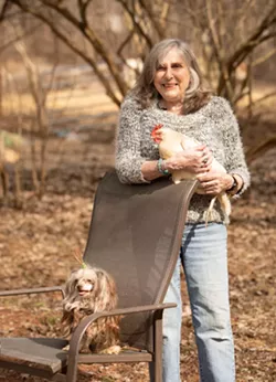 Tomasi holding a chicken alongside her dog Gigi - CAT CUTILLO