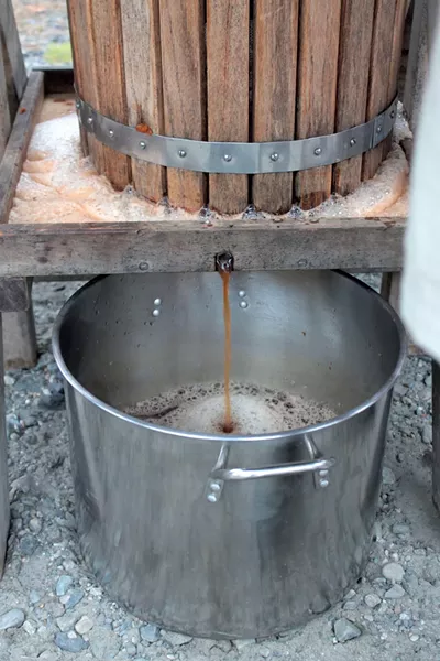 Cider collects in a stainless-steel pot - TRISTAN VON DUNTZ