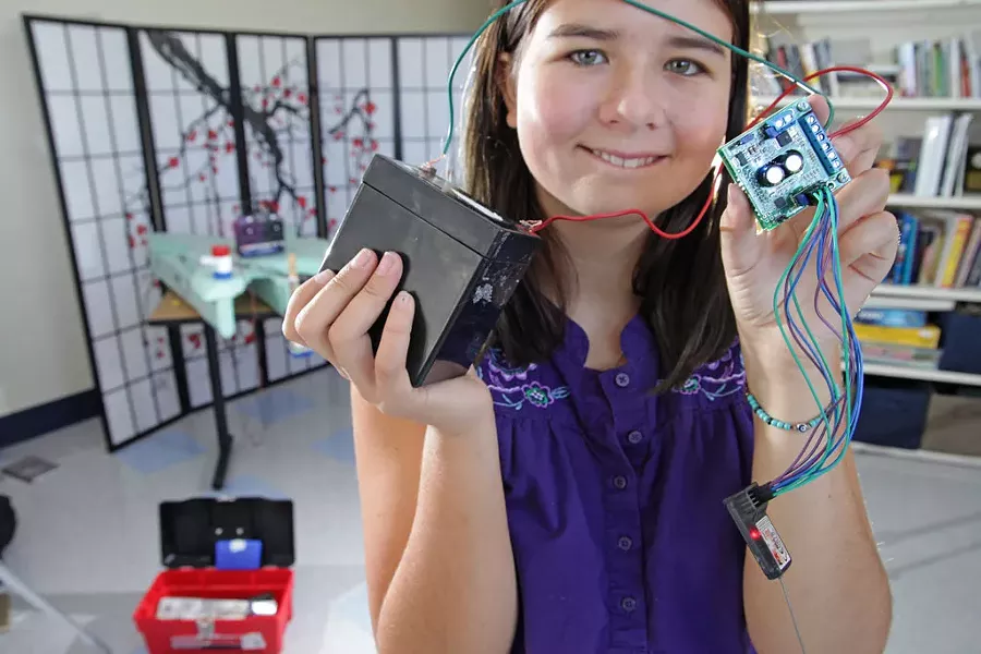 Amelia holding ChampBot parts - MATTHEW THORSEN