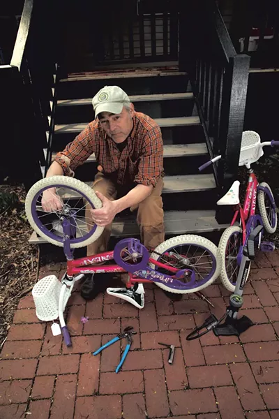 Erik Esckilsen fixes his twin daughters' bikes - MATTHEW THORSEN