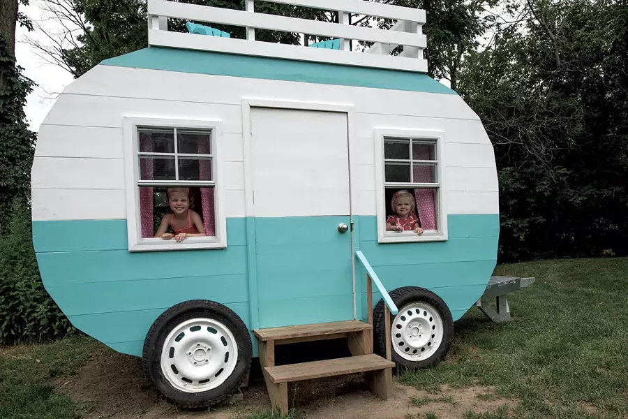 Nora and Claire peek through the working windows of their new playhouse - COURTESY OF RICH LEVINE