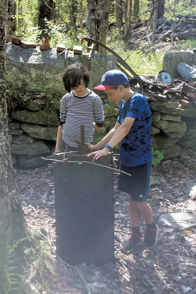 Scarlett and Jesse examining old farm machinery - HEATHER FITZGERALD