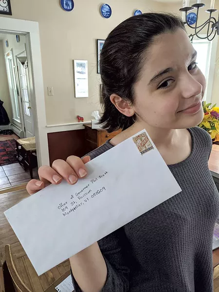 Evelyn Fleming holding up her letter to Gov. Phil Scott