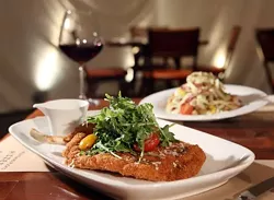 Crispy pork chop Milanese, front, and anitpasto salad, back, from Wolfgang Puck Pizzeria & Cucina in the MGM Grand Casino in Detroit. - ROB WIDDIS