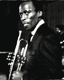 Miles Davis holds his horn.