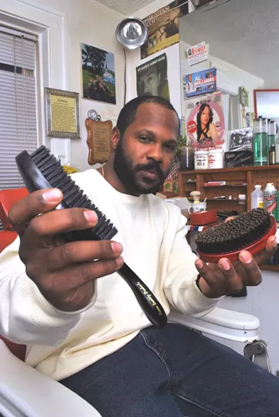 Robert Watson with his brushes in his home barbershop.