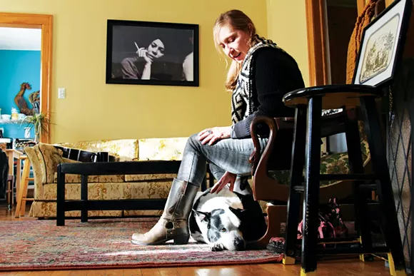 Alison Lewis relaxes with her cattle-dog mix Millie, who survived getting shot in the face by a police officer in 2015. - PHOTO BY SARAH RAHAL.