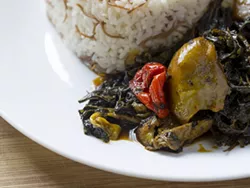 Molokhia (jute leaf) with red palm oil and pepper served with jasmine rice. - PHOTO BY JACOB LEWKOW.