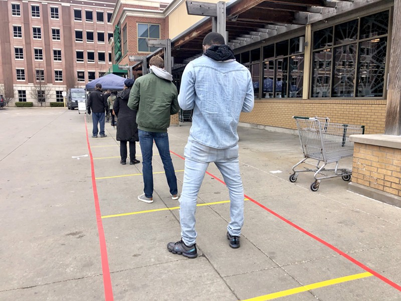 Social distancing markers guide an overflow line outside the Detroit Whole Foods store. - STEVE NEAVLING