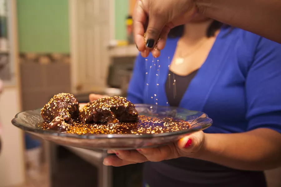 Mariana Valdez and co-chefs place the finishing touch on their mole recipe. - PHOTO BY ERIK HOWARD.