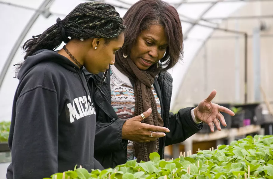 Nefer Ra Barber working with a student in a hoophouse that's used for the EAT program at Earthworks program. - TOM PERKINS