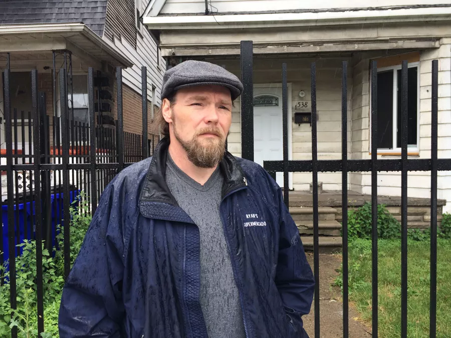 Joseph Bates, 48, stands in front of the Southwest Detroit home his great-great-grandparents bought in 1907. The home had been in his family until it was foreclosed due to unpaid tax bills. - VIOLET IKONOMOVA