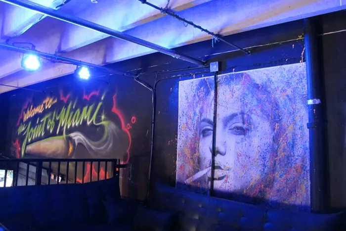 The entrance to the lounge is decorated with murals that glow beneath blue lights. - PHOTO BY NATALIA GALICZA
