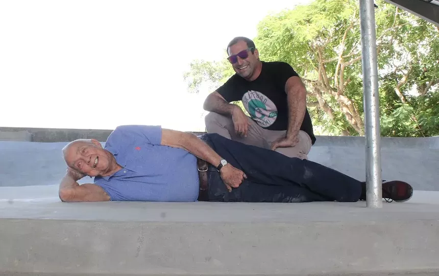 Jonathan Strauss kneels next to his landlord and longtime friend Don Bailey, 88, at SkateBird Miami. Bailey is commonly known for his partially naked flooring billboards across South Florida. - PHOTO BY JESSE FRAGA