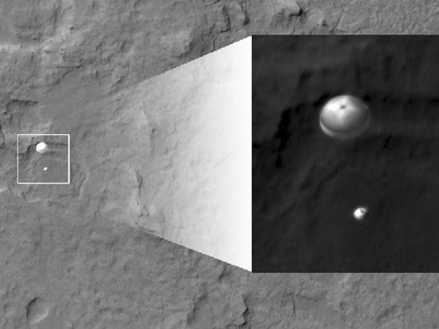 My favorite image from Curiosity's landing, taken from over 200 miles away by NASA's Mars Reconnaissance Orbiter, shows Curiosity a minute before landing, dangling beneath its 51-foot diameter parachute about two miles above Gale Crater. - NASA/JPL-CALTECH/U. OF ARIZONA