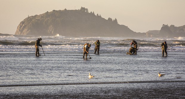 Lots of clam diggers were out on the north end of Clam Beach at sunset along with a very low tide  looking for the elusive but very tasty razor clam on Tuesday, Jan. 20. Using a long telephoto lens compressed the distance between Trinidad Head to the north and those looking for clams. - MARK LARSON