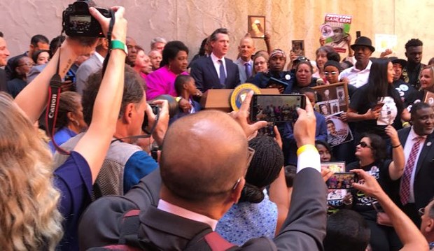 Gov. Gavin Newsom, crowd at signing ceremony for use-of-force bill. - PHOTO BY DAN MORAIN, CALMATTERS