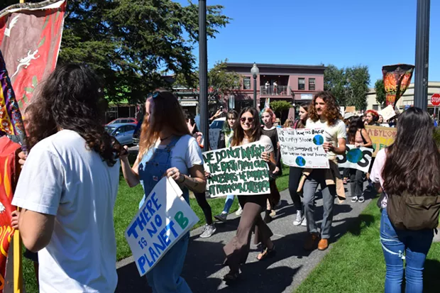Students marching towards the center of the Arcata Plaza. - IRIDIAN CASAREZ