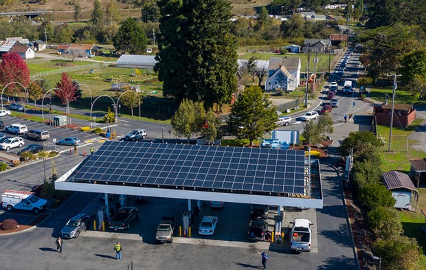 A line of cars waiting to fuel up stretches down the block at the Blue Lake Rancheria gas station, which used microgrid technology, including the solar panels above the pumps, to keep operating through the blackout. - PHOTO BY MARK MCKENNA