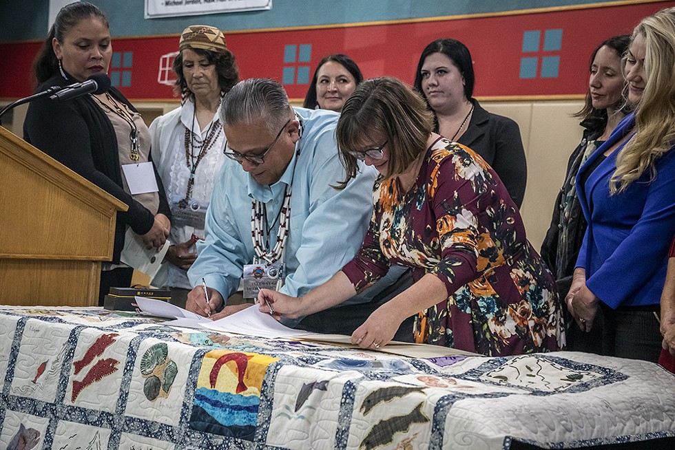 Wiyot Tribal Chair Ted Hernandez and Eureka Mayor Susan Seaman sign the land transfer paperwork. - BY MARK LARSON