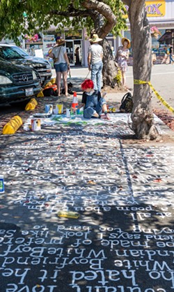 This year's festival included poetry painted on the sidewalks, such as this piece written and painted by Harvey Mitchell. - PHOTO BY MARK MCKENNA
