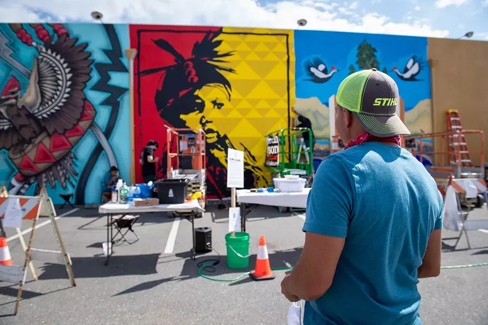 Alme Allen looks at his nearly completed mural "Arareethívthaaneen" on the back wall of the Discovery Shop on the last day of the festival. - PHOTO BY MARK MCKENNA
