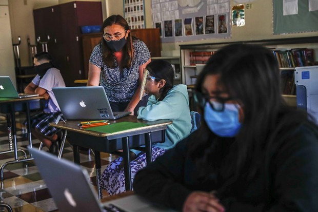 Teacher Jessica DeAnda, left, instructs Liz Valdez, 11, center, as Kayla Torres, 11, right, works on her laptop at Sunrise Middle School on June 22, 2020 in San Jose, the first Bay Area school to reopen since shelter-in-place was announced in March. - RANDY VAZQUEZ, BAY AREA NEWS GROUP