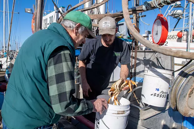 Tony Burris of the Corregidor weighs crab for former Eureka mayor and coroner Frank Jäger. - PHOTO BY MARK MCKENNA
