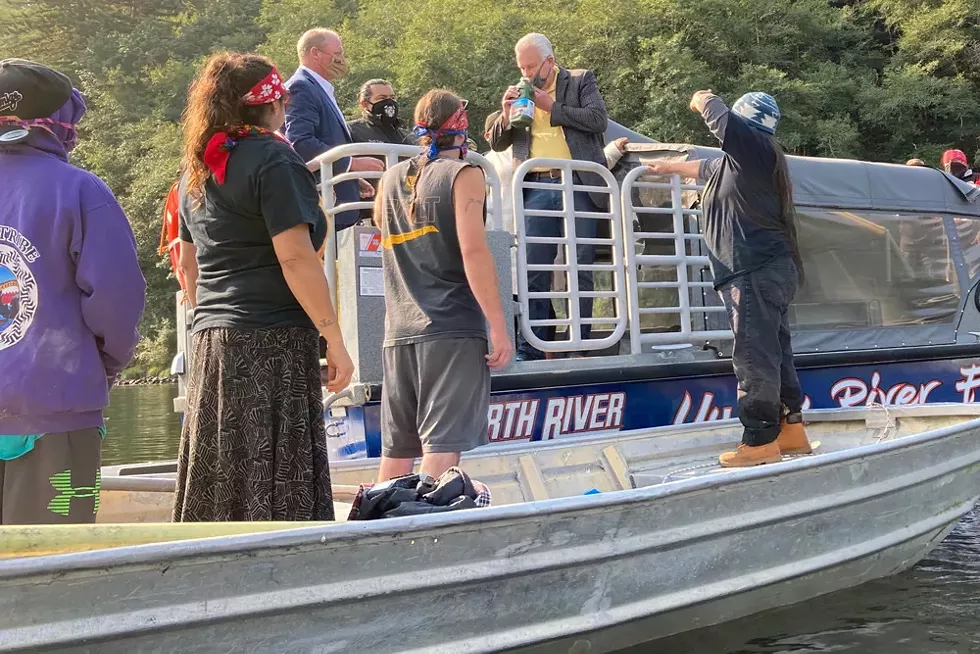Berkshire Hathaway Energy CEO William Fehrman smells a bottle of toxic algae pulled from above one of the four hydroelectric dams on the Klamath River while speaking to protesters at a blockade on Aug. 28, 2020. - SAMMY GENSAW