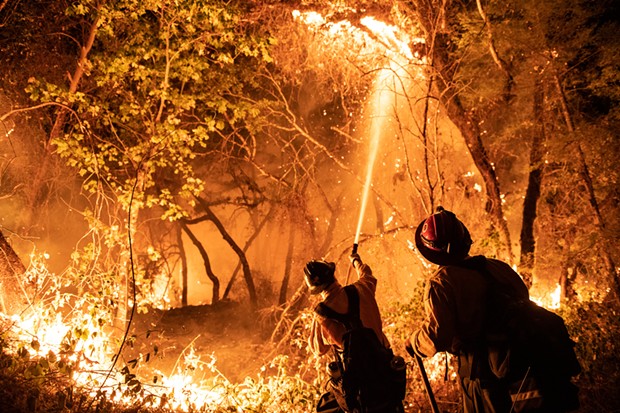 Firefighters from multiple agencies, including some that were pulled off the Monument Fire defended houses at the end of Enchanted Creek Lane on Monday. - MARK MCKENNA