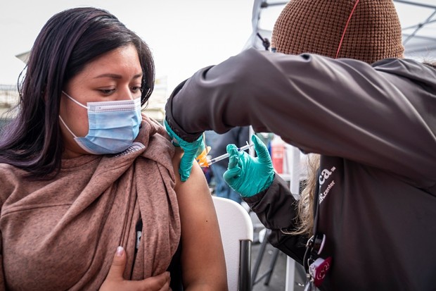 Florinda Matias Pablo receives a COVID-19 vaccination at the La Clinica de la Raza community vaccination site in Oakland on Jan. 4, 2022. - MARTIN DO NASCIMENTO/CALMATTERS