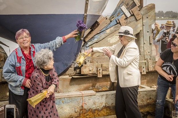 Sally Willowbee (left), Hiroshima atomic bomb survivor Shigeko Sasamori and Kitty Bigelow Benton, daughter of the original captain of the Golden Rule, apply the traditional christening prior to its launching on Saturday, June 20 at the Zerlang & Zerlang  boat yard on the Samoa peninsula. Willowbee is a daughter of one of the original Golden Rule crew members. - MARK LARSON
