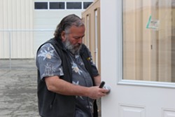 HumCPR co-founder and Humboldt County Planning Commissioner Lee Ulansey instals a doorknob on a renovated shipping container at the corner of Third and Commercial streets Friday morning. - THADEUS GREENSON