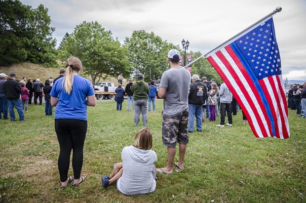 Mike Grimaldo, of Fortuna, held a flag with a blue stripe at the candlelight vigil in Fortuna on Friday evening. "The Thin Blue Line" is a symbol used to commemorate fallen law enforcement officers. - MARK LARSON