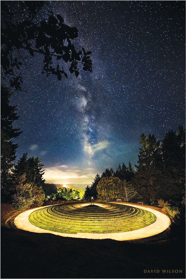 The core of the Milky Way galaxy rises in the night sky above the "All Happy Now" Earth sculpture at Humboldt Botanical Gardens. The sign reads, "Peter Santino's All Happy Now Earth Sculpture is the only one of its kind in North America. It is a merger of two ancient landscape architectural features, the ziggurat and the labyrinth. Based on a mathematical equation named Fermat's Spiral, the 100-foot diameter earth mound is covered with grass and features two non-intersecting quarter mile pathways which take the walker to the center and back down out the opposite side."