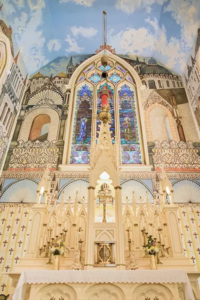 The mural surrounding the Church of the Assumption's altar, with the painted window frame bending onto the ceiling. - PHOTO BY LEÓN VILLAGÓMEZ