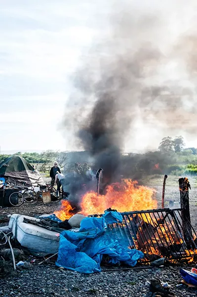Belongings blaze on the final day of the PalCo Marsh encampment. - FILE