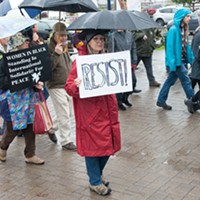 A marcher with a "Resist" sign.