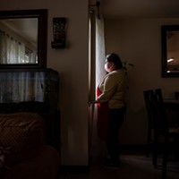 Blanca Esthela Trejo, 46, is photographed looking outside the windows near her dining room table inside her home in Salinas on April 22. Photo by David Rodriguez, The Salinas Californian