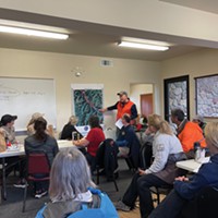 A representative of the California Rescue Dog Association walks the volunteer team through plans to use 10 search dogs with two-person handling teams to look for Emmilee Risling in rough terrain along the Klamath River.