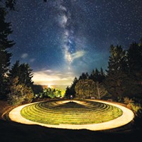 The core of the Milky Way galaxy rises in the night sky above the "All Happy Now" Earth sculpture at Humboldt Botanical Gardens. The sign reads, "Peter Santino's All Happy Now Earth Sculpture is the only one of its kind in North America. It is a merger of two ancient landscape architectural features, the ziggurat and the labyrinth. Based on a mathematical equation named Fermat's Spiral, the 100-foot diameter earth mound is covered with grass and features two non-intersecting quarter mile pathways which take the walker to the center and back down out the opposite side."