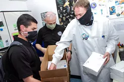 COURTESY OF HUMBOLDT COUNTY EMERGENCY OPERATIONS CENTER - Humboldt County Public Health Laboratory Manager Jeremy Corrigan (right) inspects testing reagents recently delivered by the California National Guard 59th Civil Support Team in Hayward.