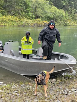 PHOTO BY ALLIE HOSTLER/TWO RIVERS TRIBUNE - Police help load a trained cadaver dog and her handler onto a boat to be transported to search the Klamath River between Blue Creek and the Klamath Glen for Emmilee Risling.