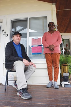 PHOTO BY THADEUS GREENSON - Lance and Lydia Nally sit by the red tags that still adorn their house, despite them having gone into debt to repair the home's foundation. "It's kind of a tag of pride now," Lance Nally says. "We made it, and we're still here."